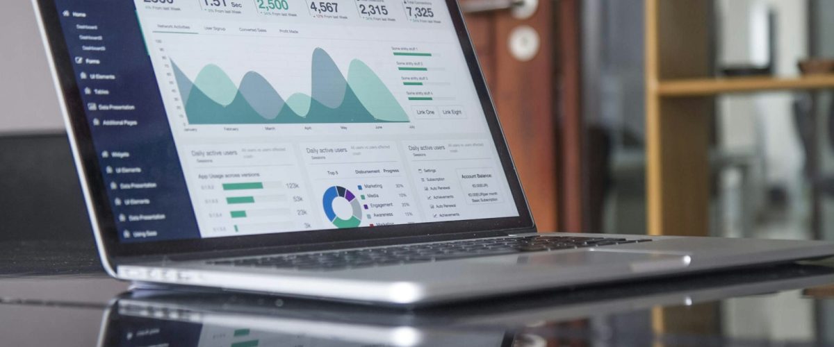 Marketing analytics dashboard on a laptop with sticky notes — website conversion planning session