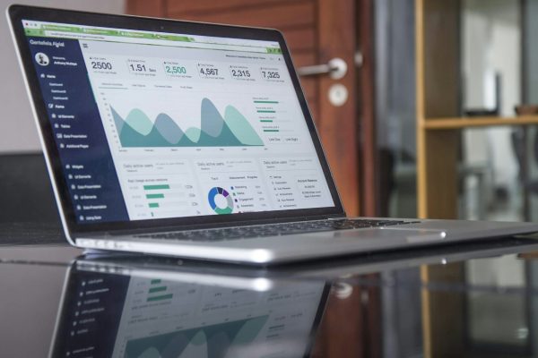 Marketing analytics dashboard on a laptop with sticky notes — website conversion planning session